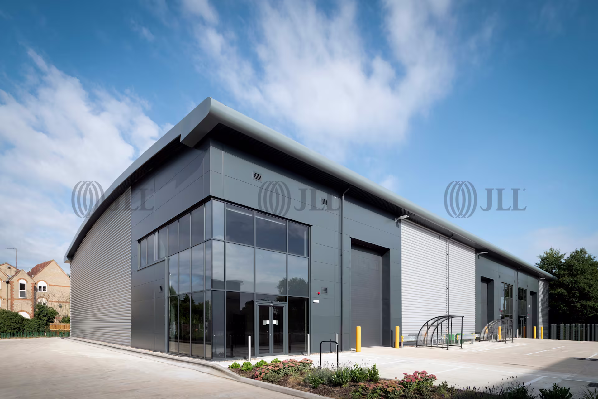 Exterior of a Waltham X warehouse unit with a glazed corner entrance, loading doors and cycle shelters